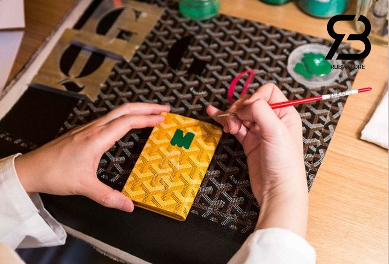 Nghệ nhân đang vẽ trên ví Goyard