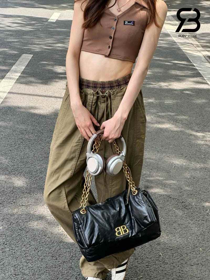 Nữ mang túi Balenciaga đen với outdit croptop nâu và quần xanh olive