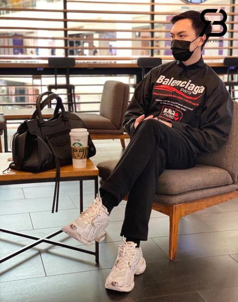 Nam đeo túi Balenciaga đen với outfit đen, giày trắng